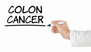 Hand with pen writing Colon Cancer