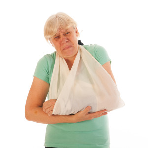 Old woman with broken wrist in blue gypsum isolated over white background