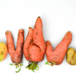 Ugly vegetables: carrots, spinner and apple on white background.